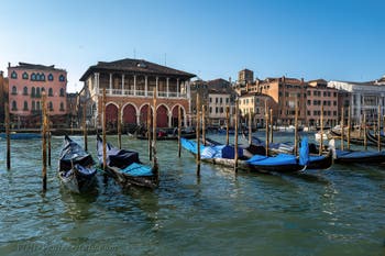 Gondolas on Venice Grand Canal in front of the Rialto market.