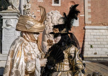 Nobles in black and gold at the Arsenal, the masks and costumes of the Venice Carnival. 