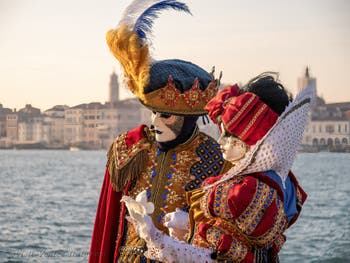 On the island of San Giorgio Maggiore, two magnificent costumes in glorious colours with Snow White and the Seven Dwarves on the princess's dress from the Venetian carnival.