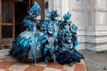 Venetian carnival costumed figures in front of the church of San Zaccaria.