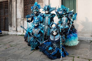 Venetian carnival costumed figures in front of the church of San Zaccaria.