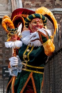 Venetian carnival costumed figures in front of the church of San Zaccaria.