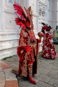 Venetian carnival costumed figures in front of the church of San Zaccaria.