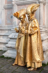 Venetian carnival costumed figures in front of the church of San Zaccaria.