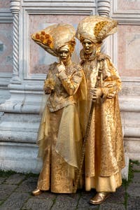 Venetian carnival costumed figures in front of the church of San Zaccaria.