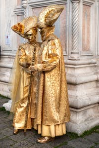 Venetian carnival costumed figures in front of the church of San Zaccaria.