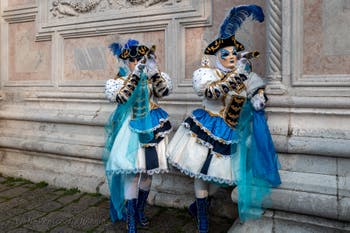 Venetian carnival costumed figures in front of the church of San Zaccaria.