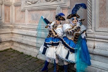 Venetian carnival costumed figures in front of the church of San Zaccaria.