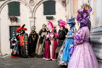 Venetian carnival costumed figures in front of the church of San Zaccaria.