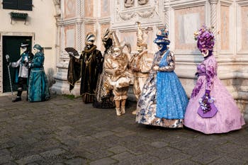 Venetian carnival costumed figures in front of the church of San Zaccaria.