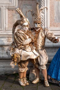 Venetian carnival costumed figures in front of the church of San Zaccaria.