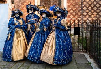 Venetian carnival costumed figures in front of the church of San Zaccaria.