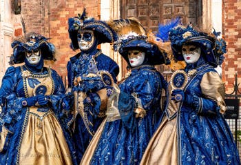 Venetian carnival costumed figures in front of the church of San Zaccaria.