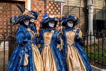 Venetian carnival costumed figures in front of the church of San Zaccaria.