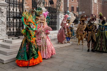 People in costume at the Venice Carnival in front of the Venetian Arsenal.