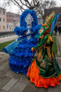 People in costume at the Venice Carnival in front of the Venetian Arsenal.