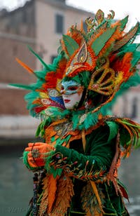 People in costume at the Venice Carnival in front of the Venetian Arsenal.