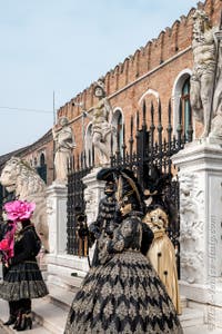 People in costume at the Venice Carnival in front of the Venetian Arsenal.