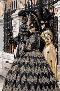 People in costume at the Venice Carnival in front of the Venetian Arsenal.