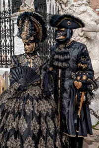 People in costume at the Venice Carnival in front of the Venetian Arsenal.