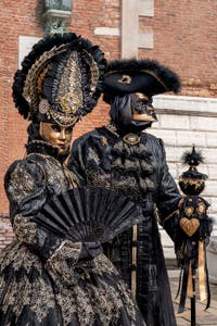 People in costume at the Venice Carnival in front of the Venetian Arsenal.