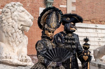 People in costume at the Venice Carnival in front of the Venetian Arsenal.