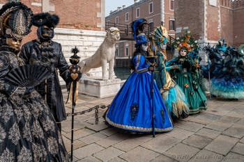 People in costume at the Venice Carnival in front of the Venetian Arsenal.