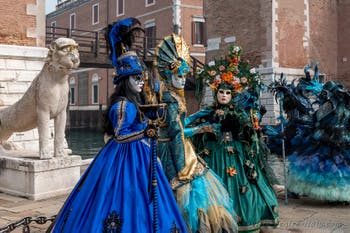 People in costume at the Venice Carnival in front of the Venetian Arsenal.