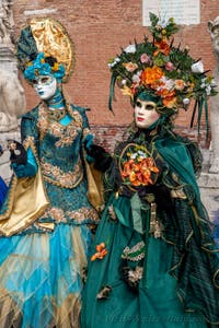 People in costume at the Venice Carnival in front of the Venetian Arsenal.