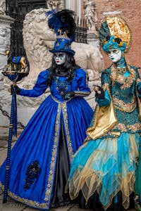 People in costume at the Venice Carnival in front of the Venetian Arsenal.