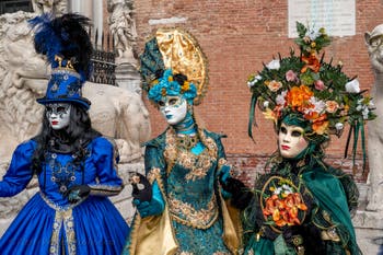 People in costume at the Venice Carnival in front of the Venetian Arsenal.