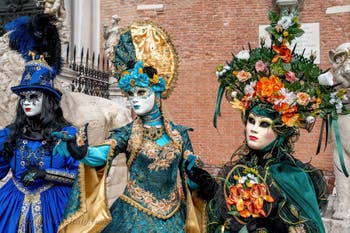 People in costume at the Venice Carnival in front of the Venetian Arsenal.