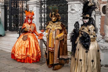 People in costume at the Venice Carnival in front of the Venetian Arsenal.