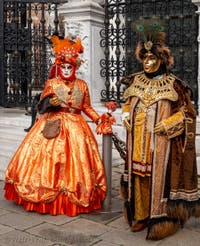 People in costume at the Venice Carnival in front of the Venetian Arsenal.