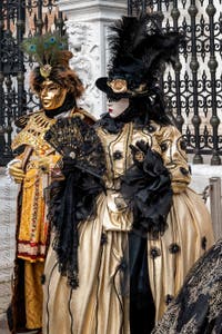 People in costume at the Venice Carnival in front of the Venetian Arsenal.