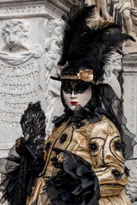 People in costume at the Venice Carnival in front of the Venetian Arsenal.