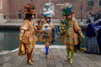 People in costume at the Venice Carnival in front of the Venetian Arsenal.