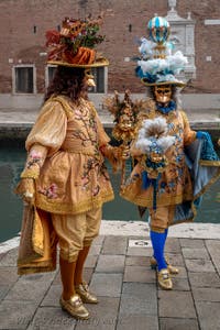 People in costume at the Venice Carnival in front of the Venetian Arsenal.