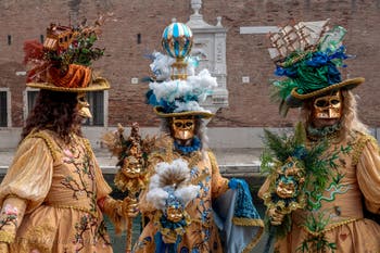 People in costume at the Venice Carnival in front of the Venetian Arsenal.