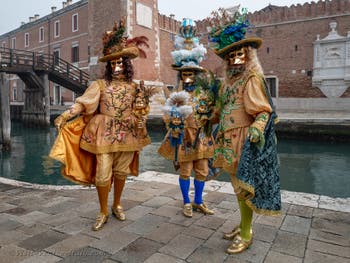 People in costume at the Venice Carnival in front of the Venetian Arsenal.