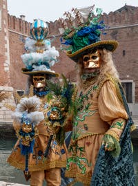 People in costume at the Venice Carnival in front of the Venetian Arsenal.