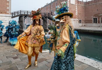 People in costume at the Venice Carnival in front of the Venetian Arsenal.