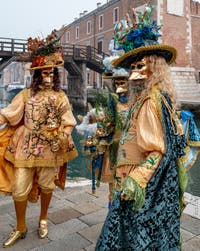 People in costume at the Venice Carnival in front of the Venetian Arsenal.