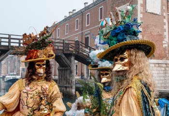 People in costume at the Venice Carnival in front of the Venetian Arsenal.