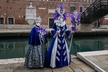 People in costume at the Venice Carnival in front of the Venetian Arsenal.