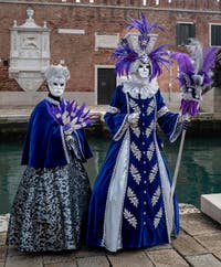 People in costume at the Venice Carnival in front of the Venetian Arsenal.