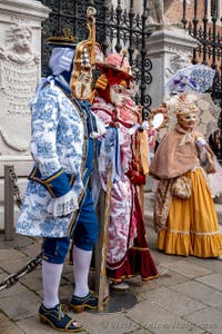 People in costume at the Venice Carnival in front of the Venetian Arsenal.