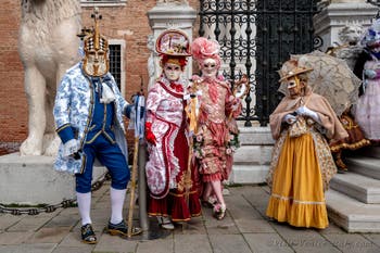 People in costume at the Venice Carnival in front of the Venetian Arsenal.