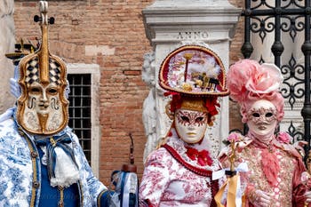 People in costume at the Venice Carnival in front of the Venetian Arsenal.