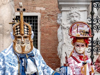 People in costume at the Venice Carnival in front of the Venetian Arsenal.